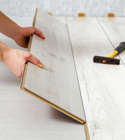 male hands is laying wooden panel of laminate floor indoors close-up. male hands is laying wooden panel of laminate floor indoors close-up. Laminate flooring, copy space